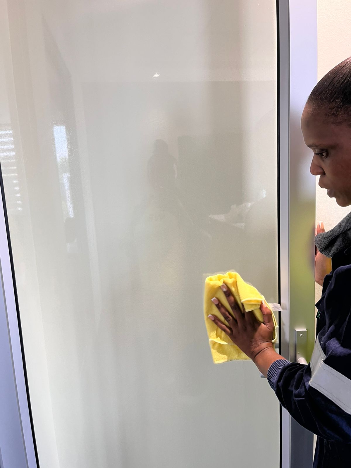 Worker wiping a frosted glass door